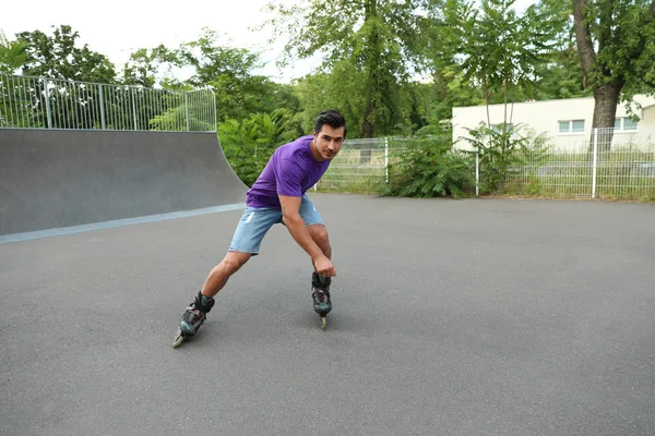 Knappe jonge man roller skating in Park — Stockfoto