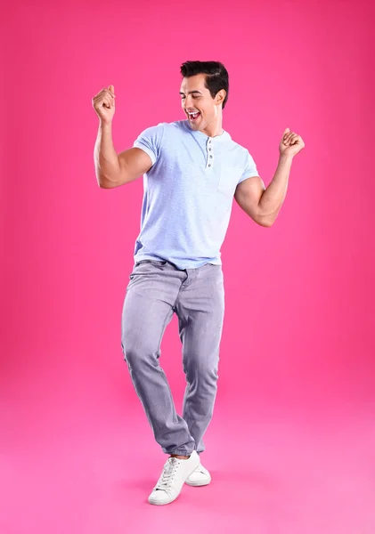 Jóképű fiatalember táncol rózsaszín háttér — Stock Fotó