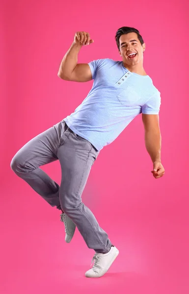 Yakışıklı genç adam pembe arka plan üzerinde dans — Stok fotoğraf