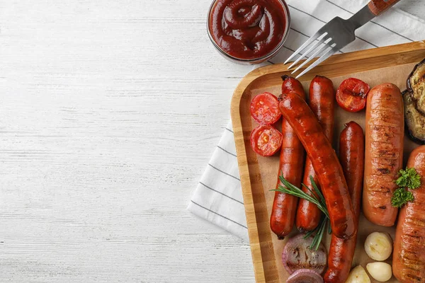 Flat lay composition with delicious grilled sausages on white wooden table, space for text. Barbecue food — Stock Photo, Image