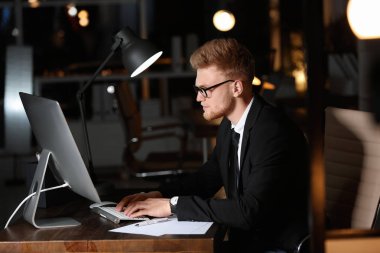 Konsantre genç işadamı geceleri ofiste tek başına çalışıyor