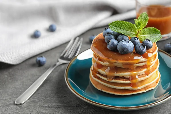 Délicieuses crêpes aux myrtilles fraîches et sirop sur table grise — Photo