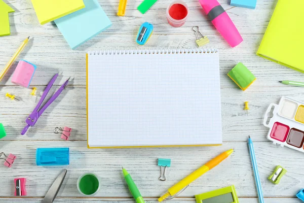 Verschillende school briefpapier en lege laptop op witte houten achtergrond, platte lag. Ruimte voor tekst — Stockfoto