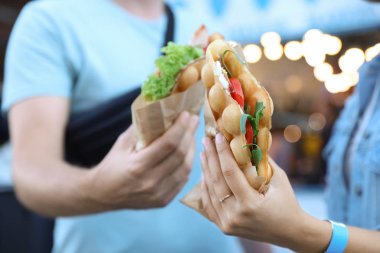 Genç çift domates ve arugula açık havada lezzetli kabarcık waffle tutan, closeup