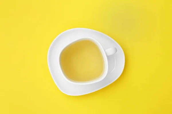 노란색 배경에 차와 접시 한 잔, 상단보기 — 스톡 사진