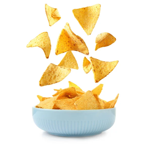 Delicious Mexican nachos chips falling into bowl on white background — Stock Photo, Image