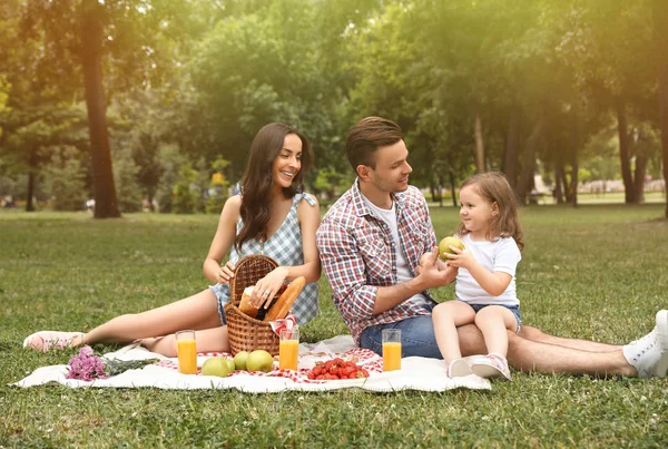 Familie fericită cu picnic în parc în ziua însorită — Fotografie, imagine de stoc