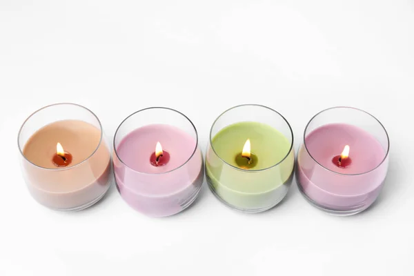 Velas de cera de color en soportes de vidrio aislados en blanco — Foto de Stock