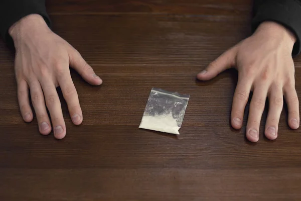 Criminoso com droga na mesa de madeira, vista acima — Fotografia de Stock