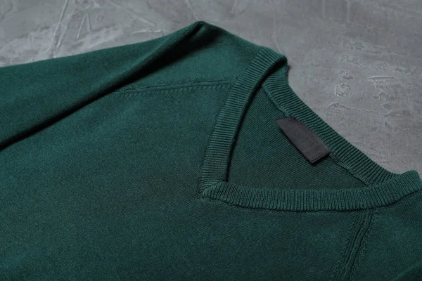 Groene trui op grijze achtergrond, close-up. Nieuwe stijlvolle school uniform — Stockfoto