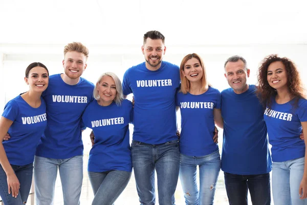 Equipe de voluntários de uniforme em fundo claro — Fotografia de Stock