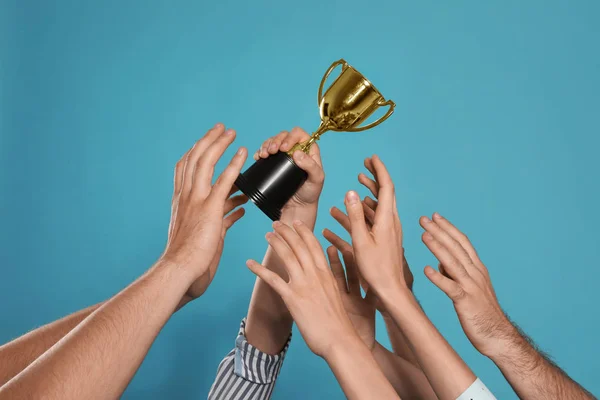 Menschen mit goldenem Pokal auf blauem Hintergrund, Nahaufnahme — Stockfoto