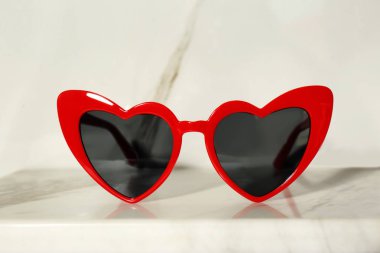 Açık arka planda kalp şeklinde şık güneş gözlüğü