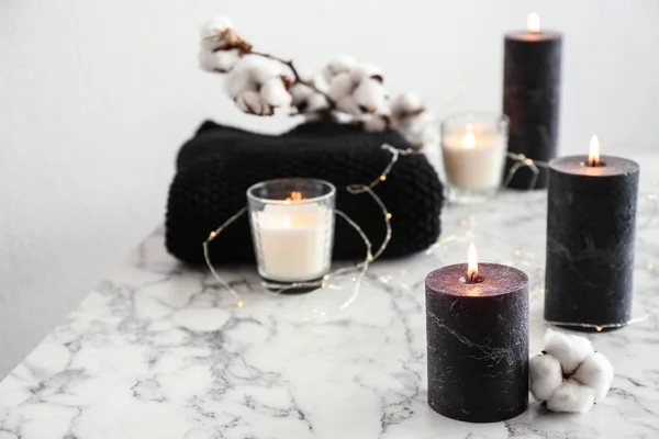Queimando velas e flor de algodão com luzes de fadas na mesa de mármore — Fotografia de Stock