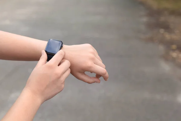 Jovem a verificar pulsação com smartwatch na rua, close-up. Espaço para texto — Fotografia de Stock