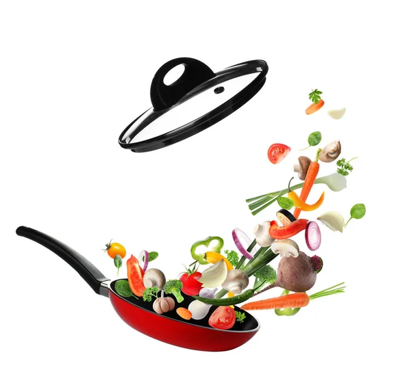 Many different vegetables falling into frying pan on white background — Stock Photo, Image