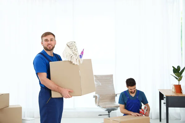 Hombres jóvenes en uniforme trabajando en interiores. Servicio móvil — Foto de Stock