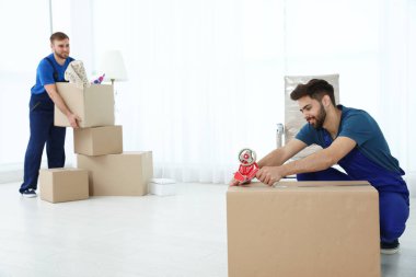 Üniformalı genç adamlar içeride çalışıyor. Taşıma hizmeti