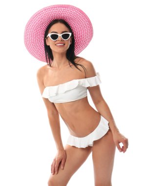 Beyaz arka planda şapkalı şık bikinili güzel genç kadın