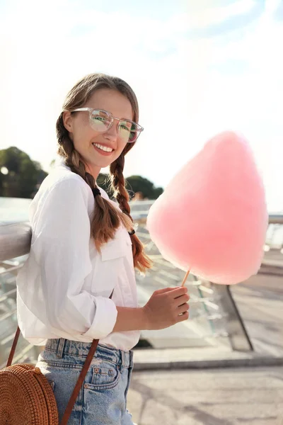 Mujer joven con algodón de azúcar al aire libre en el día soleado —  Fotos de Stock