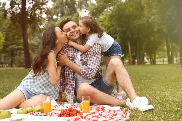 Lycklig familj med picknick i parken på solig dag — Stockfoto