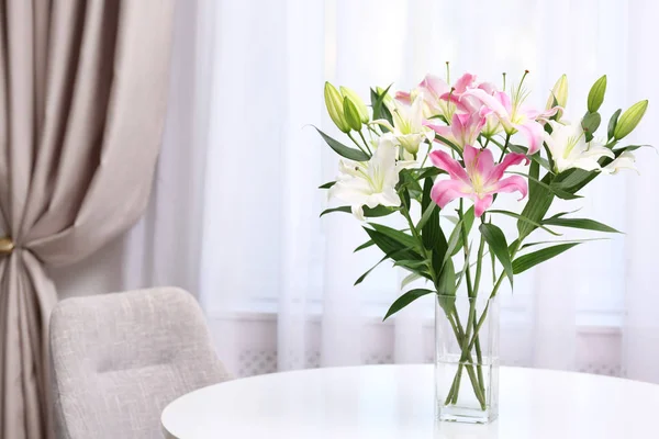 Vas dengan karangan bunga bunga lili yang indah di atas meja putih di dalam ruangan. Ruang untuk teks — Stok Foto