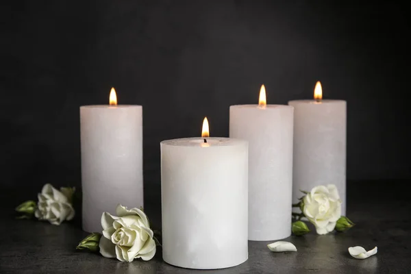 Queimando velas e belas flores na mesa cinza — Fotografia de Stock