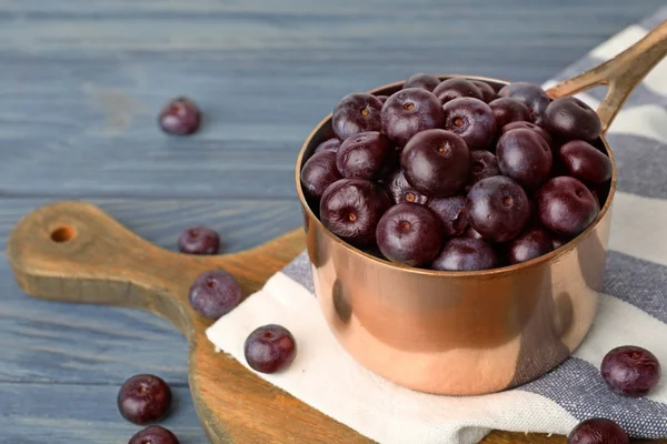 Металлическая кастрюля из свежих ягод асаи на голубом деревянном столе, место для текста — стоковое фото