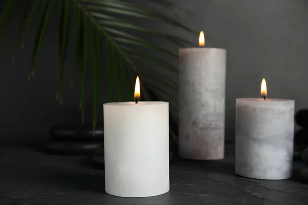Горящие свечи и спа-камни на черном столе — стоковое фото