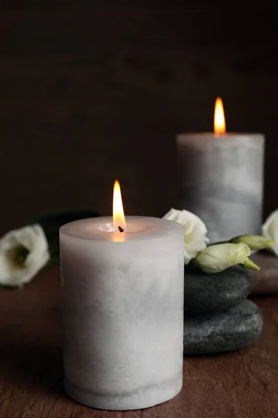 Queimando velas, pedras de spa e flores na mesa de madeira, espaço para texto — Fotografia de Stock
