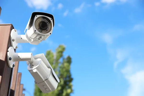 Modernas cámaras de seguridad CCTV contra el cielo azul. Espacio para texto —  Fotos de Stock