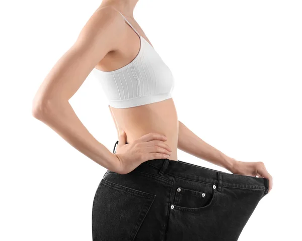 Jonge slanke vrouw dragen oversized jeans op witte achtergrond, close-up — Stockfoto