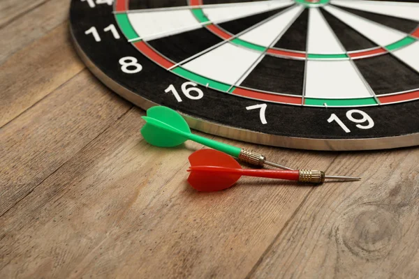 Dart board with color arrows on wooden background. Space for text — Stock Photo, Image