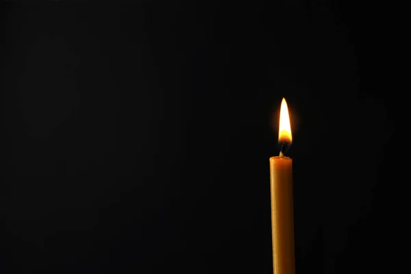 Спалювання свічки на темному тлі, простір для тексту. Символ печалі — стокове фото