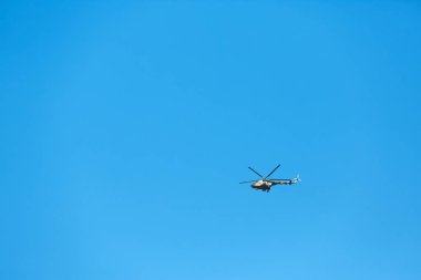 Mavi gökyüzünde uçan modern askeri helikopter