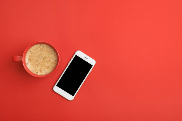 Cup of coffee and phone on red background, top view. Space for text — Stock Photo, Image