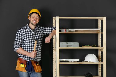 İçeride çekiçle sert şapkalı yakışıklı işçi adam. Ev onarımı