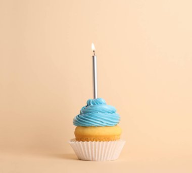 Bej arka planda mum ile Doğum günü cupcake