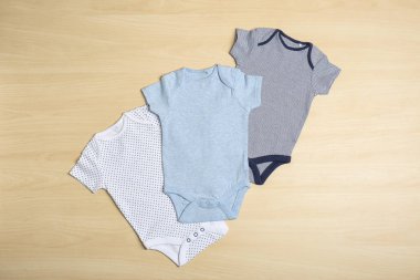 Ahşap arka planda farklı bebek Body, üst görünüm