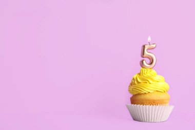 Mor arka plan üzerinde beş numaralı mum ile Doğum günü cupcake, metin için alan