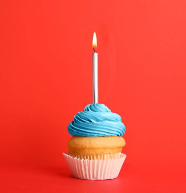 Kırmızı arka plan üzerinde mum ile Doğum günü cupcake