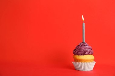Kırmızı arka plan üzerinde mum ile Doğum günü cupcake, metin için alan