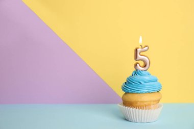 Renk arka plan üzerinde beş numaralı mum ile Doğum günü cupcake, metin için alan