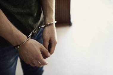 İçeride kelepçeli olarak gözaltına alınan adam, mesaj için yer. Ceza hukuku