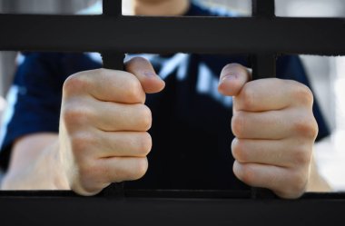 Dışarıda hapiste, yakın çekimde gözaltına alınan adam. Ceza hukuku