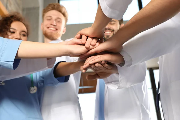 Equipo de trabajadores médicos tomados de la mano en primer plano hispital. Concepto de unidad —  Fotos de Stock