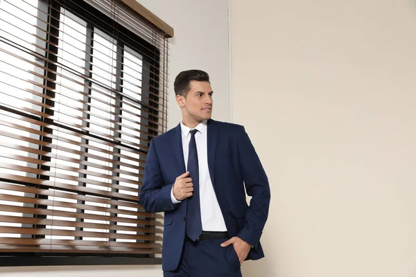 Portrait of confest business in suit at window indoors — Stok Foto