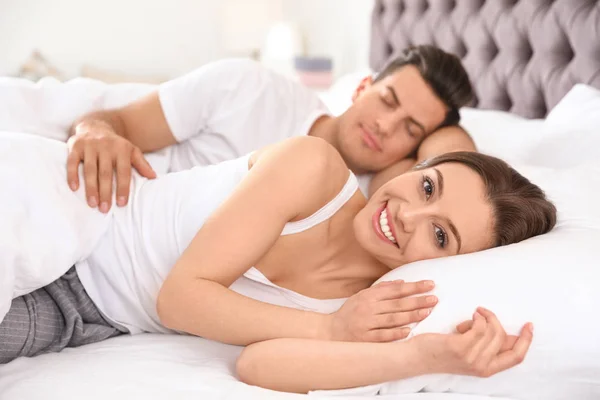 Schönes junges Paar ruht sich auf großem bequemen Bett aus — Stockfoto