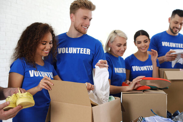 Team of volunteers collecting donations in boxes indoors