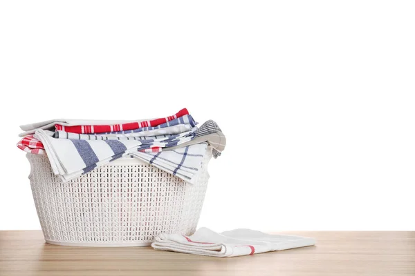 Cesta con ropa limpia sobre mesa de madera, fondo blanco — Foto de Stock